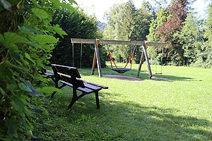Der Park lädt mit Bank und Korbschaukel zum Entspannen ein.