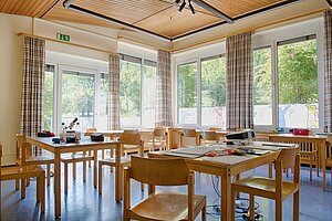 Klassenzimmer im Schullandheim Leinach. Es stehen Tischgruppen im Raum. 