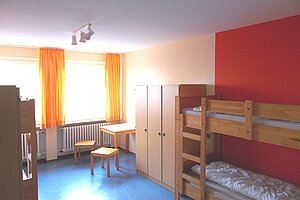 Ein Schlafzimmer mit Hochbetten und Schrank