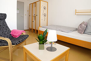 Das Zimmer für Lehtkräfte mit einem Bett und Sitzecke lädt zum Entspannen ein.