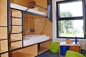 Im Neubau sind die Betten in ein Holzregal eingelassen. Pro Zimmer kommen bis zu sechs Gäste unter.