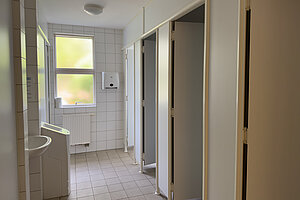 Badezimmer mit Waschbecken und Duschkabinen.